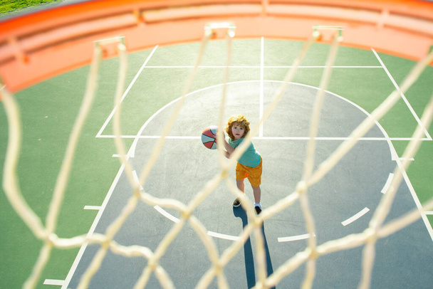 Kid playing basketball with ball. Basketball child player. Child sport activity. - Foto, afbeelding