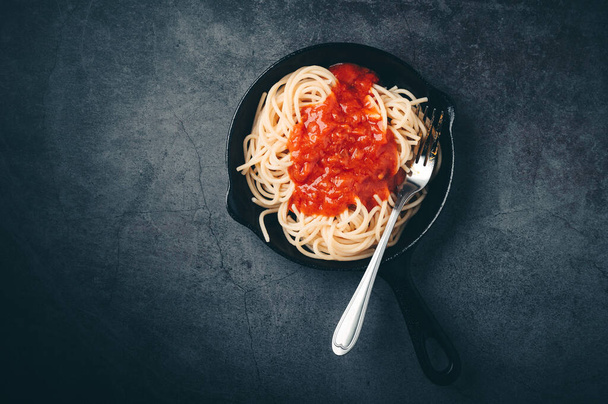 Espaguetis con salsa de tomate y carne picada, queso parmesano y albahaca Fondo negro. Espacio de copia vista superior. - Foto, Imagen