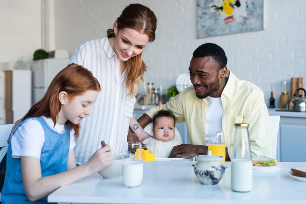 happy multiethnic family smiling during breakfast in kitchen - Zdjęcie, obraz