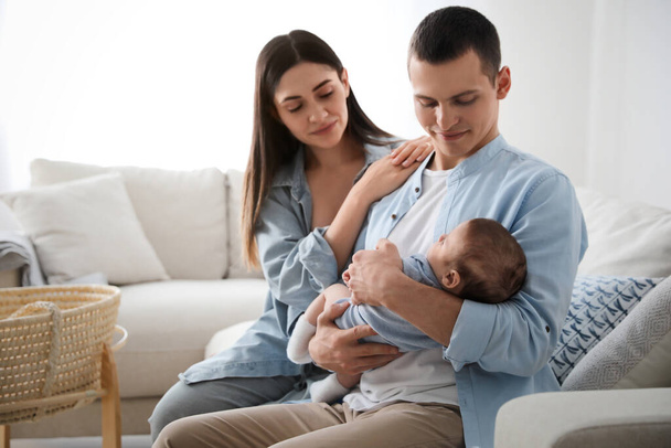Happy family with cute baby on sofa at home - Photo, Image