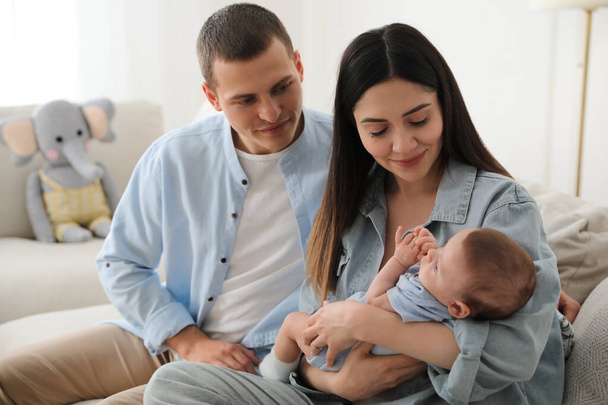 Happy family with cute baby on sofa at home - Фото, зображення