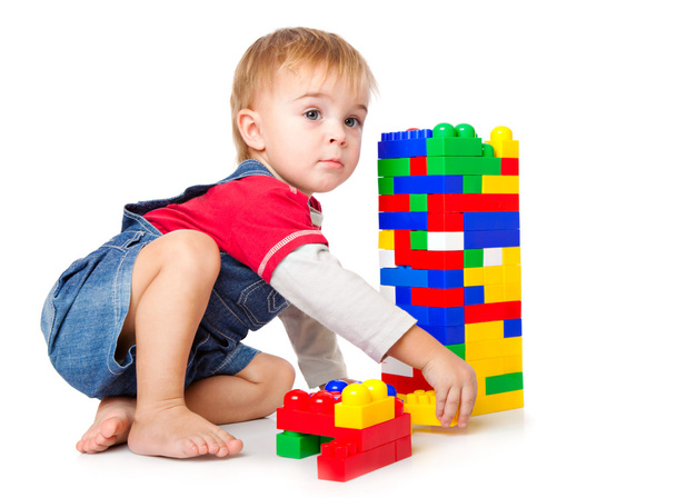 A funny boy is playing with lego. isolated on a white background - Photo, Image