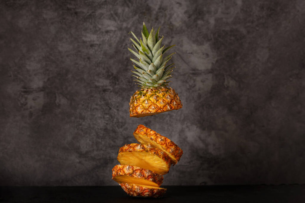 Гавайские ананасы. Нарезанный и весь ананас (Ananas comosus). Креативная компоновка из соснового яблока. - Фото, изображение