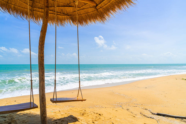 swing on beach with ocean sea and blue sky background - Zdjęcie, obraz