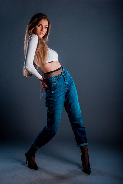 Plan du corps d'une fille moderne cool portant un haut blanc et un jean bleu - Photo, image