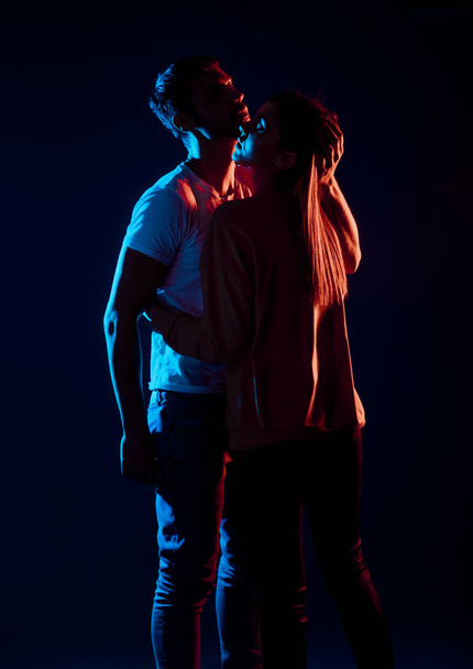 Sensual loving man and woman posing against a black background - Фото, изображение