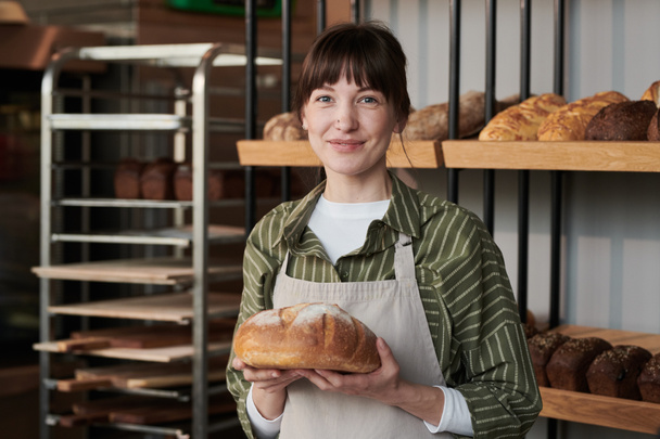 Woman with fresh bread in the shop - 写真・画像