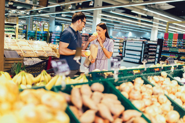 Couple heureux achetant des fruits à l'épicerie ou au supermarché  - Photo, image