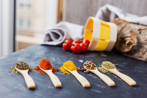 The wooden spoons with spices, paprika, basilic, pepper, thyme with cherry tomatoes - Foto, Imagem