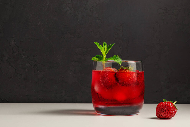 cold, homemade, strawberry lemonade with ice in glass glasses, mint leaves and berries on a dark background - Photo, Image