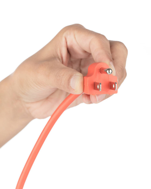 Χέρι κρατώντας πορτοκαλί καλώδιο επέκτασης απομονώνονται σε λευκό φόντο - Φωτογραφία, εικόνα