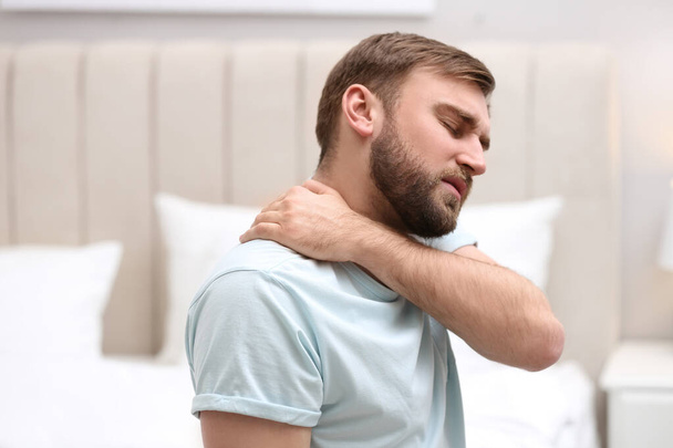 Man suffering from neck pain at home. Bad posture problem - Φωτογραφία, εικόνα
