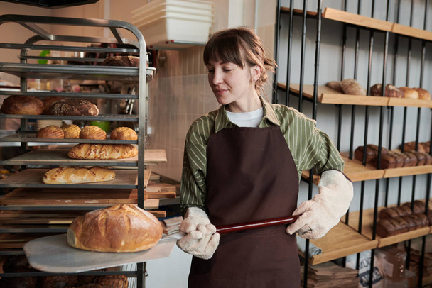Mujer joven horneando pan en el horno - Foto, Imagen