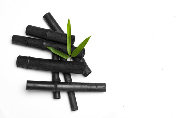 Bâtonnets de charbon actif de bambou et feuille verte isolés sur fond blanc. - Photo, image