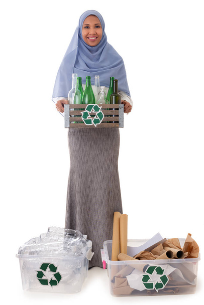 Çevre ve çevre kavramı - plastik şişelerle tesettürlü gülümseyen Asyalı Müslüman kadın, cam şişeler ve kavanozlarla dolu tahta kutular taşıyan kağıt çöpler, beyaz arka planda izole edilmiş - Fotoğraf, Görsel