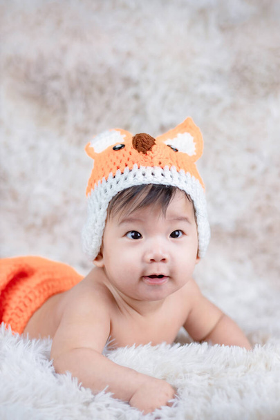 Дитина в в'язаному капелюсі з вухами лисиці та костюмом кролика
. - Фото, зображення