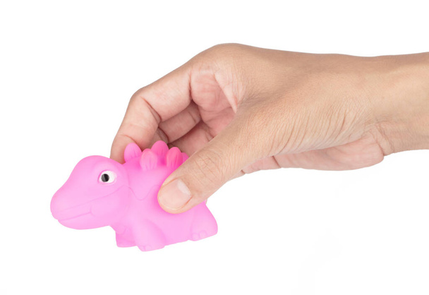 Hand holding A rubber dolls dinosaur isolated on white background - Foto, immagini