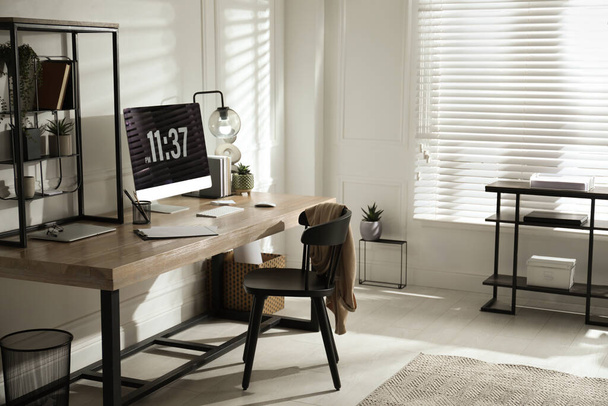 Room interior with comfortable workplace. Modern computer on wooden desk - Fotó, kép