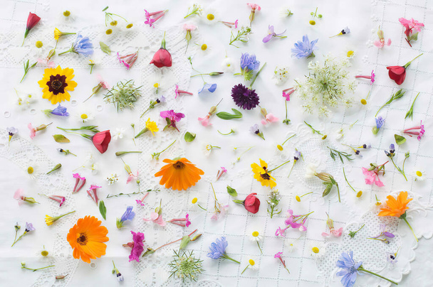 Blossoms of summer flowers on white tablecloth - Foto, Imagem