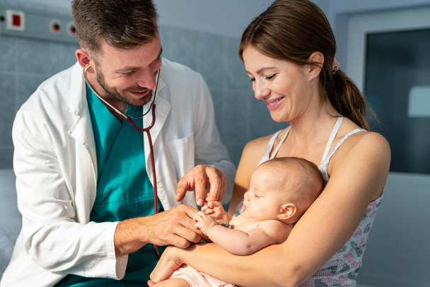 Mother holding baby for pediatrician doctor to examine. People healthcare concept - Foto, afbeelding