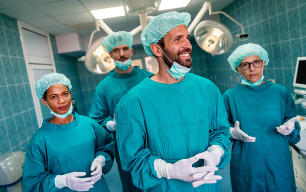 Portrait of successful team of surgeon standing in operating room, ready to work on a patient - Zdjęcie, obraz