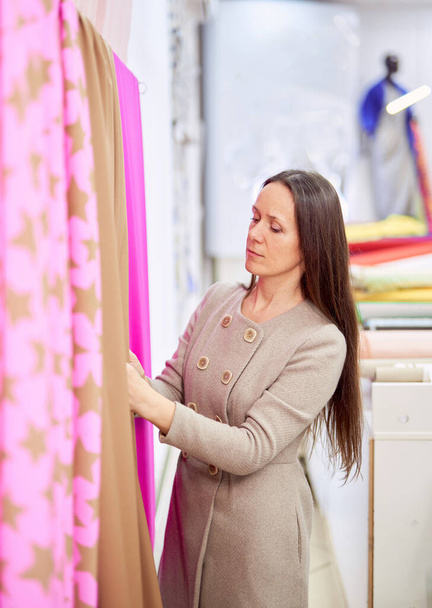 Właściciel sklepu Drapery patrząc na jasny kolor tkaniny włókienniczej - Zdjęcie, obraz