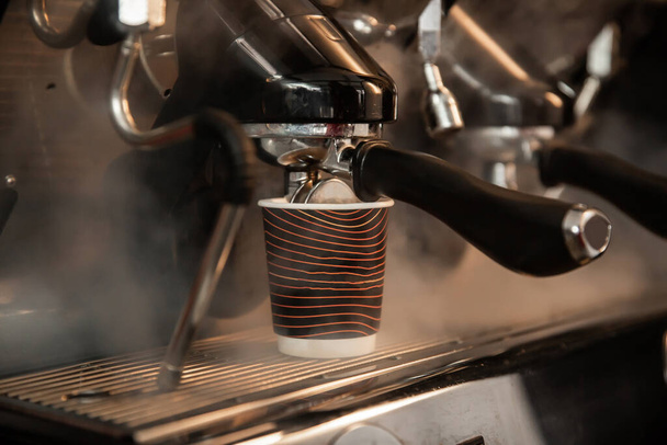 καφέ εργαζόμενος κάνοντας καφέ σε επαγγελματική καφετιέρα κοντά, μπορεί να είναι φόντο για νόστιμα προϊόντα  - Φωτογραφία, εικόνα