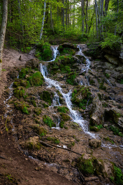 Hermosa cascada de bosque lluvioso de montaña con agua de flujo rápido y rocas, larga exposición. Viajes naturales de temporada fondo al aire libre con sol - Foto, imagen