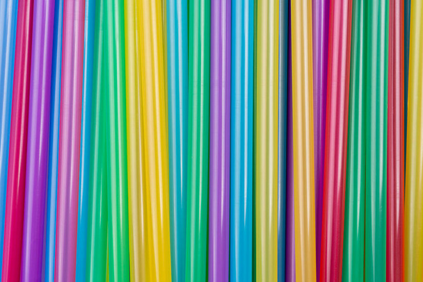 Bovenaanzicht van gemengde gekleurde plastic rietjes. Sluit tot tal van kleurrijke rietjes achtergrond, verbod plastic rietjes voor het opslaan van milieu concept. Cocktail buizen gemengde kleur achtergrond - Foto, afbeelding