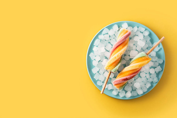 Spiral colorful popsicle with fruit on yelow background - Foto, imagen