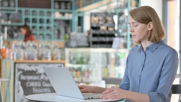 Young Woman Coming Back Opening Laptop in Cafe - Photo, Image