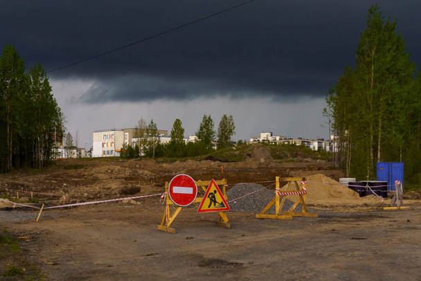 Дорога закрыта для ремонта на окраине города и штормовых облаков над ним. Петрозаводск, Карелия - Фото, изображение