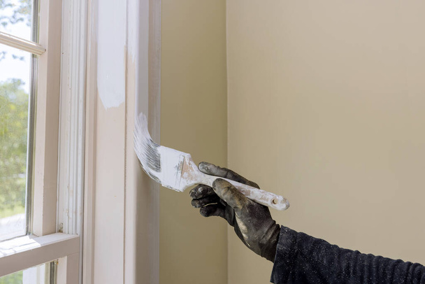 Main de réparateur peinture avec des gants dans la garniture de moulage de fenêtre de peinture - Photo, image