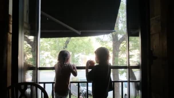 Αδελφός και αδελφή τρώνε νόστιμα ψωμάκια στη βεράντα του εστιατορίου - Πλάνα, βίντεο