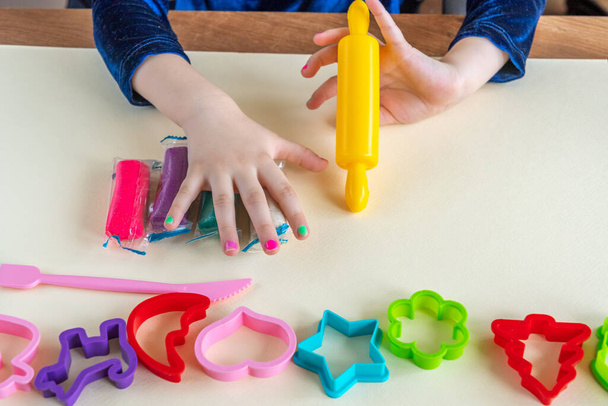 Dziewczyna maluch ręce gry kolorowe ciasto grać z tworzyw sztucznych form i żółty wałek pin - Zdjęcie, obraz