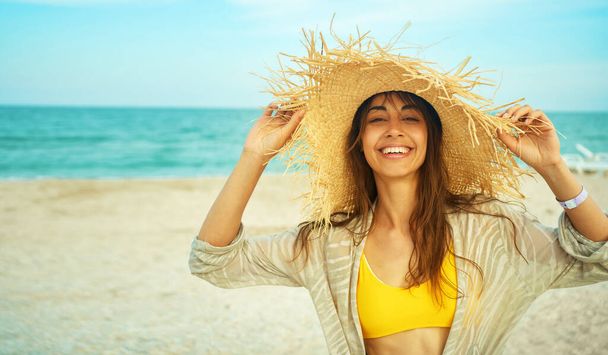 portrait happy bright summer woman with beautiful smile in big straw hat at beach - Foto, imagen