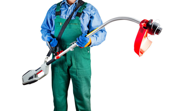 Isolated photo of worker in green overalls holding electric garden trimmer on white background. - Photo, Image