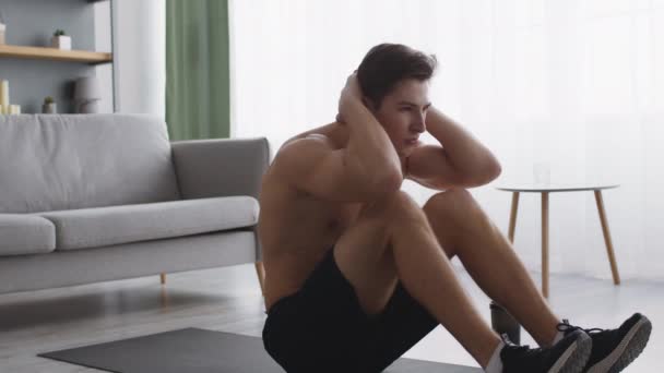 Abs cvičení doma. Sporty svalnatý muž dělat křupky na podlaze, cvičení s nahý trup sám - Záběry, video