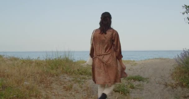 美しいですイタリアの女の子とともに黒ブーツと白いパンツで海で歩く夏 - 映像、動画