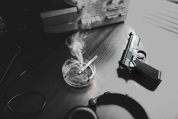 Reel tape recorder for wiretapping. KGB spying conversations. Black and white photo. Gun lying nearby. Ashtray with a cigarette. - Photo, Image