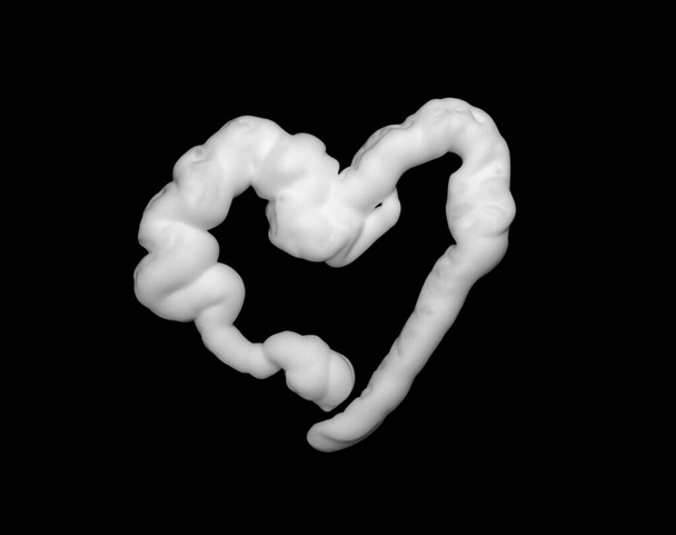 Espuma de afeitar en forma de corazón aislada sobre fondo negro - Foto, Imagen