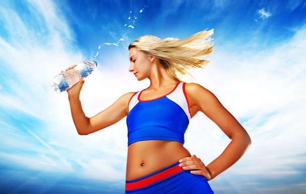 jonge vrouw drinkwater na fitness oefening - Foto, afbeelding