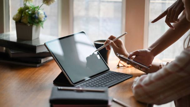 Oldalkép gyönyörű nő csíkos ing rajz fehér üres képernyő számítógép tabletta információk szerint a barátai, hogy áll mellette rendezett nappali, mint a háttér. - Fotó, kép