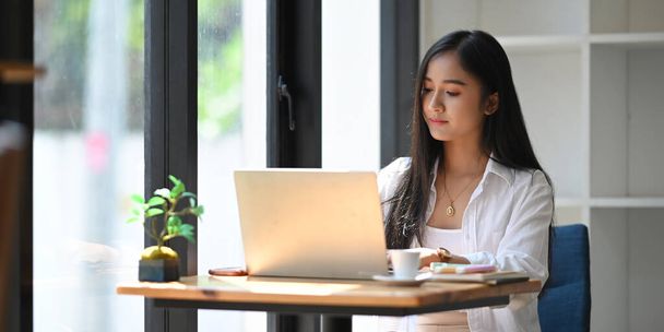 mujer asiática usando laptop en cafetería - Foto, imagen