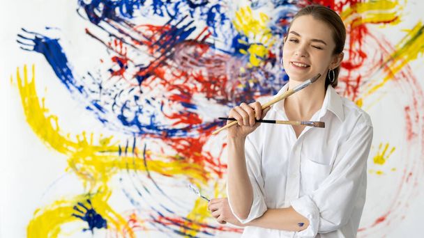 fun painting woman with paintbrushes colorful wall - Fotografie, Obrázek