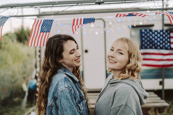 A lovely shot of two Spanish females on background of the US flags - US Independence day - Photo, Image