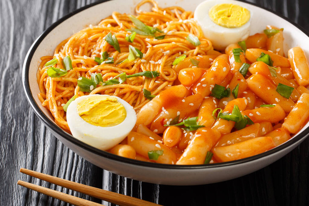 Spicy Rabokki ist eine Variation von Tteokbokki mit Ramen-Nudeln, die mit gekochten Eiern in der Schüssel auf dem Tisch serviert werden. Horizonte - Foto, Bild