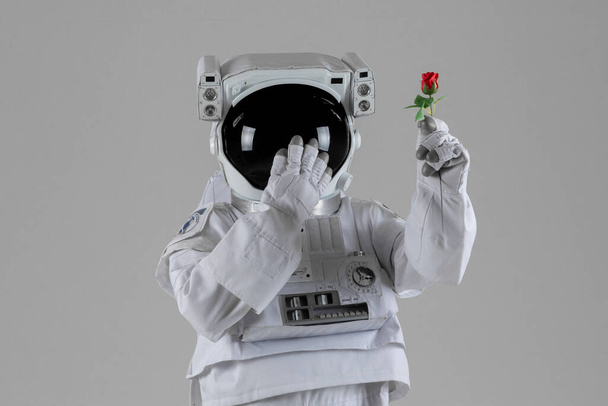 Astronaut surprised holding a rose, white background - Foto, Imagem