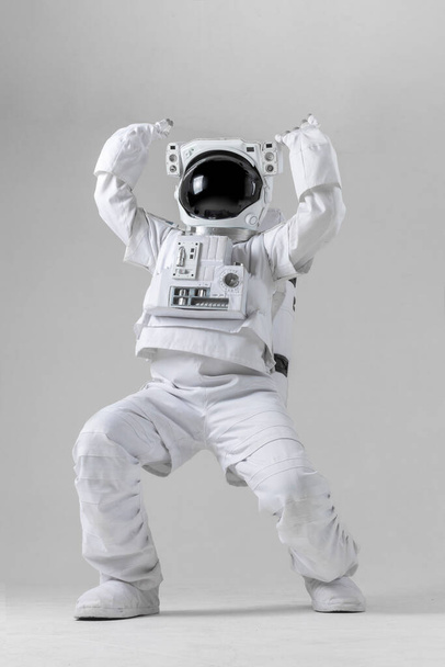 Astronaut holding a large object, white background - Foto, imagen