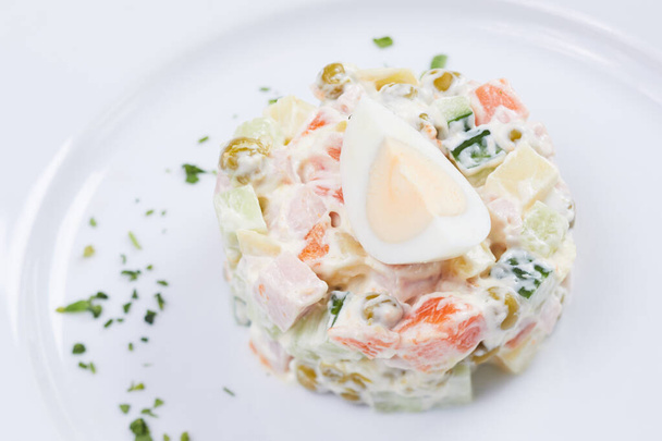 orosz saláta fehér tálcán, közelről  - Fotó, kép